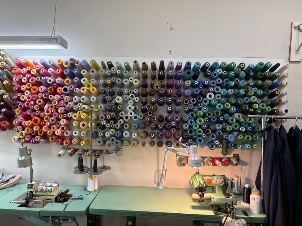 Sewing workstation with colorful thread spools and industrial machines